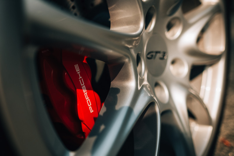 A close-up of a Porsche GT3 car wheel with a red brake caliper